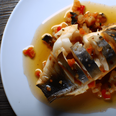 Il baccalà alla calabrese è un piatto tradizionale ricco di sapori mediterranei. Il pesce viene cotto con pomodori, cipolla, sedano, pinoli, uvetta e olive nere, servito su fette di pane croccante. Con un tocco speciale di origano, questo piatto offre un viaggio culinario nel cuore della Calabria.